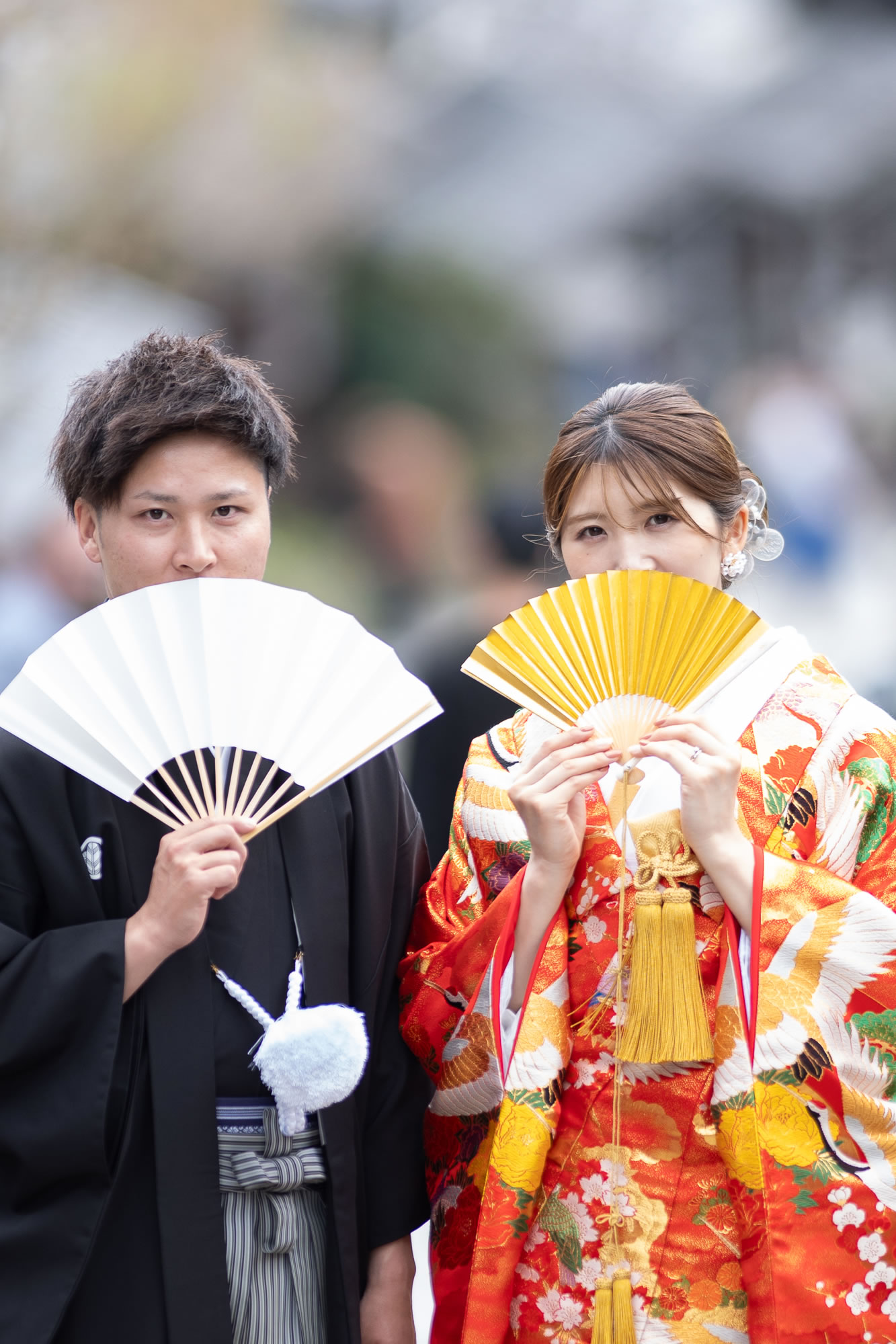扇子で口元を隠す新郎新婦