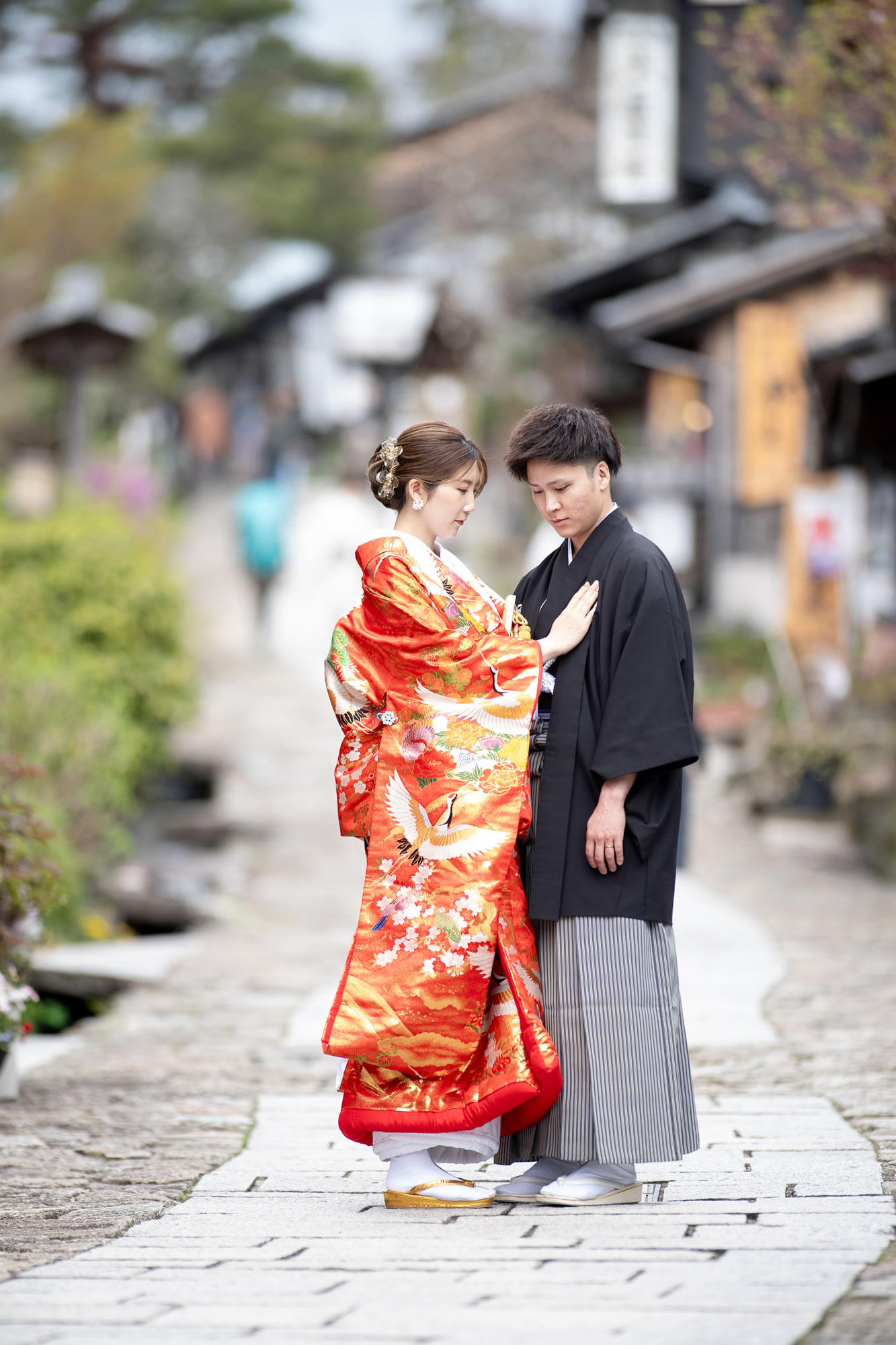 馬籠のまっすぐ伸びる坂の前の新郎新婦